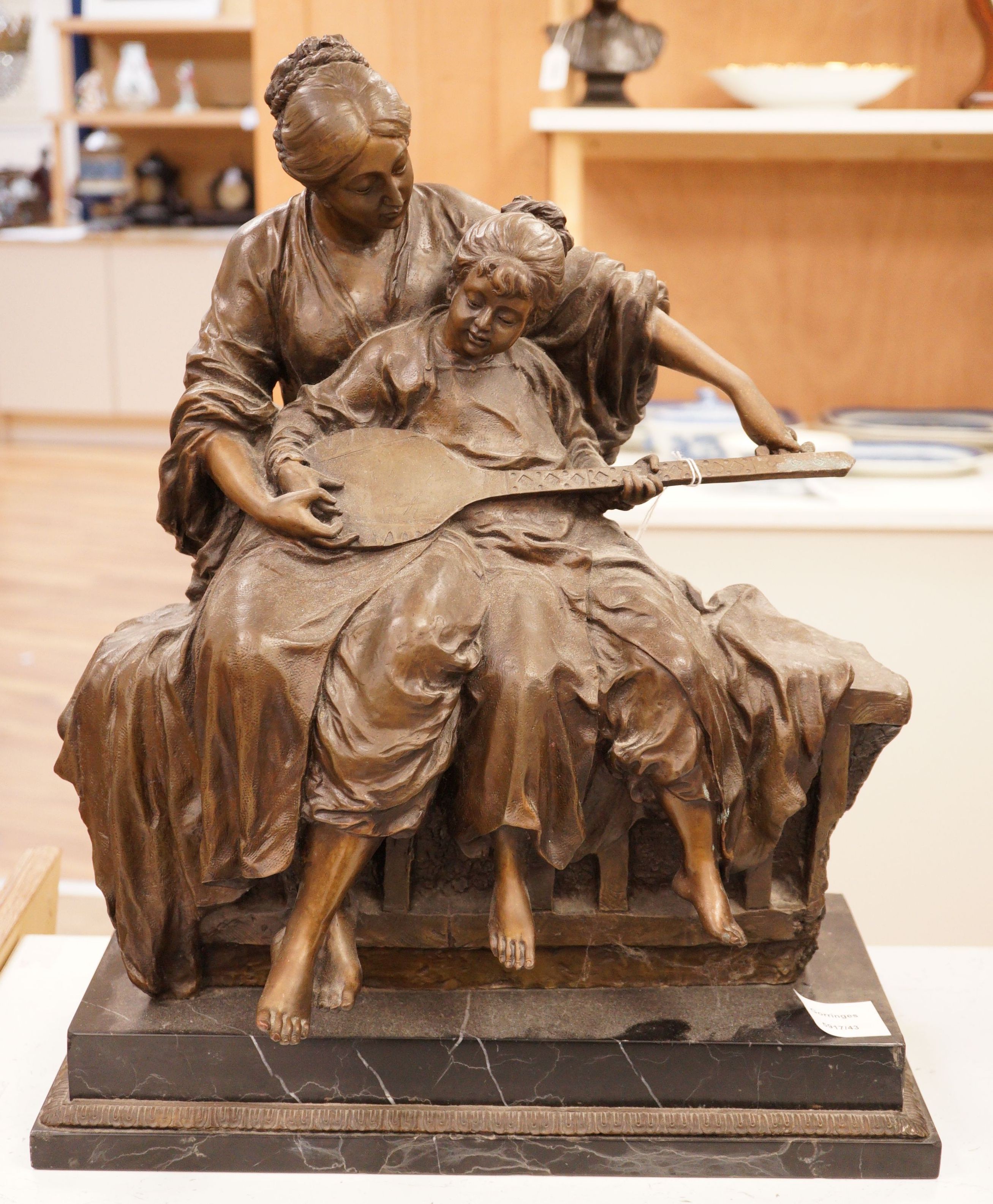 A large bronze figural group, 'learning to play', 51cm tall